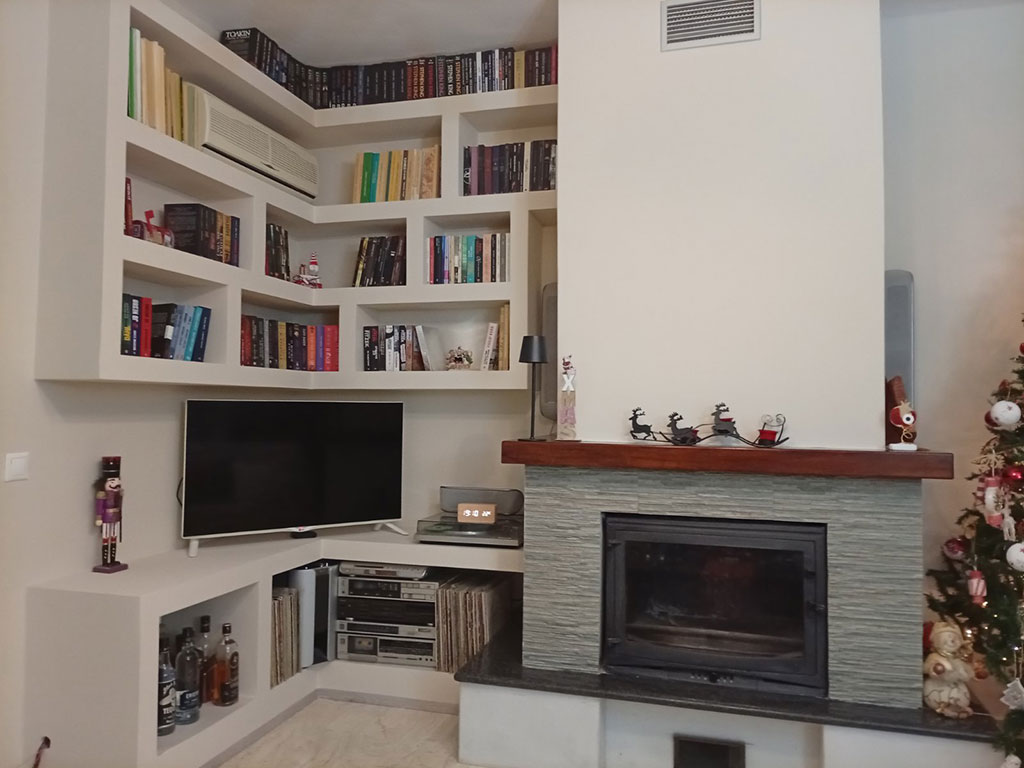 Γωνιακή βιβλιοθήκη γυψοσανίδας με σύνθεση τηλεόρασης δίπλα σε τζάκι στην Παλλήνη