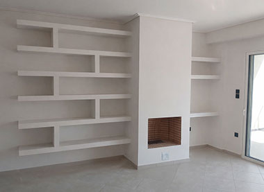 Τζάκι και ράφια από γυψοσανίδα δεξιά και αριστερά του.